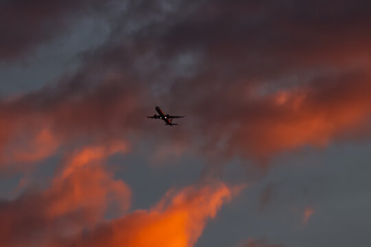 A passenger airplane taking off against a dramatic morning sky.