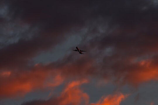 A passenger airplane taking off against a dramatic morning sky.