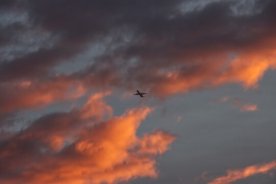 A passenger airplane taking off against a dramatic morning sky.