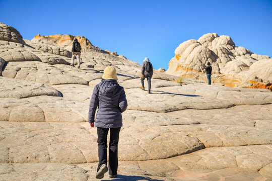 A group of people climbing up the rocks in winter. White Pocket. Vermilion Cliffs National Monument. Arizona. USA.