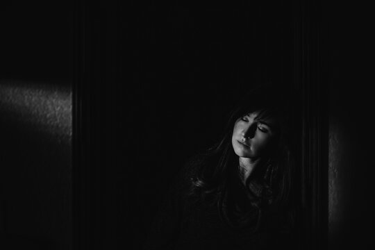 Woman's face illuminated by light in the dark
