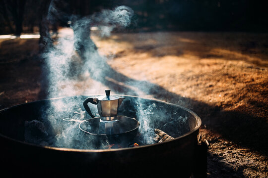 Steaming moka pot brewing coffee on a campfire
