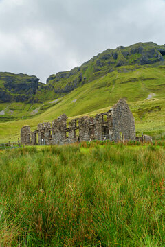 Abandoned stone ruin in a lush green mountain valley, Ireland