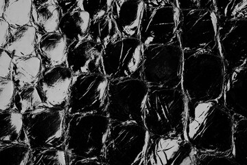 Dark exotic reptile leather texture with glossy python scales for luxury fashion background © reddish