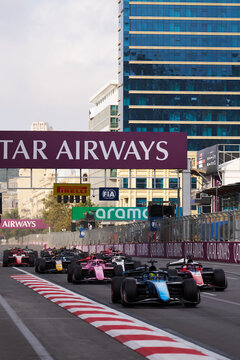 BAKU, AZERBAIJAN - SEPTEMBER 2026: Pack of Formula 2 cars racing along the main straight past the overhead gantry at the Azerbaijan Grand Prix