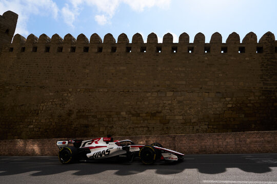 BAKU, AZERBAIJAN - SEPTEMBER 2026: MoneyGram Haas F1 Team race car speeds alongside the ancient Old City fortress wall during the Azerbaijan Grand Prix