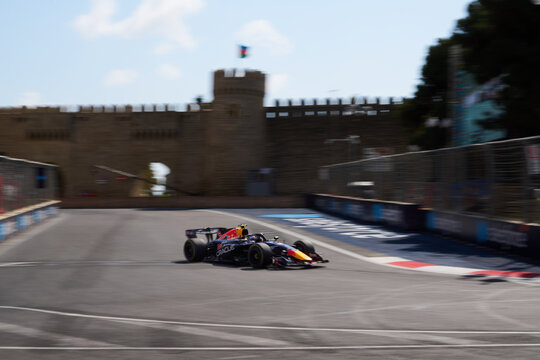 BAKU, AZERBAIJAN - SEPTEMBER 2026: Oracle Red Bull Racing car speeds along the Baku City Circuit near the historic Old City castle wall during the Grand Prix