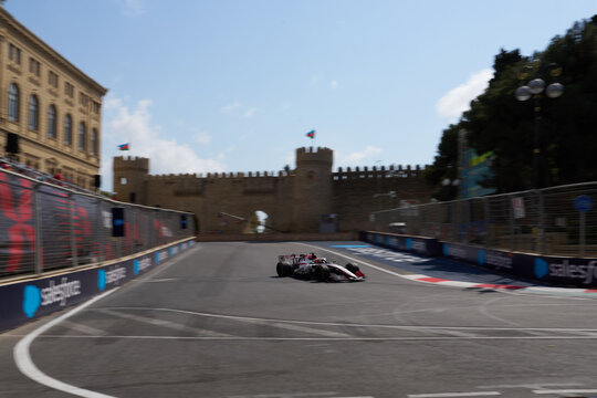 BAKU, AZERBAIJAN - SEPTEMBER 2026: MoneyGram Haas F1 Team car speeds along the Baku City Circuit near the historic Old City castle wall during the Grand Prix