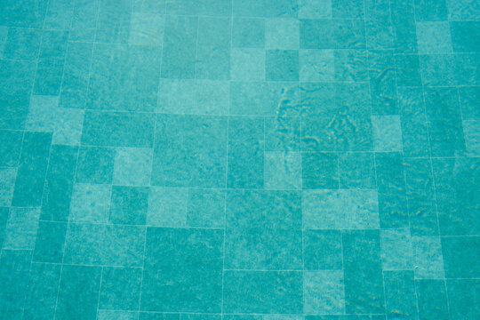 Turquoise water ripples over tiled pool background
