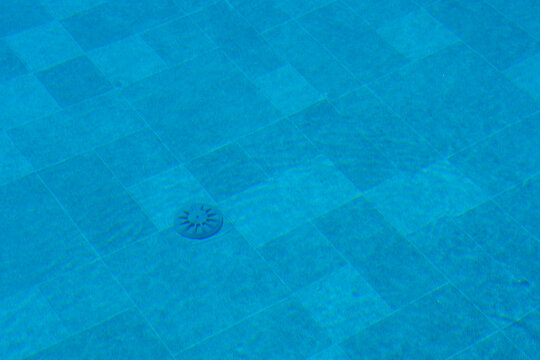 Water surface with tile background and drain fitting