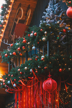 Festive outdoor decorations with colorful baubles glowing string lights red ribbons and a round red lantern.