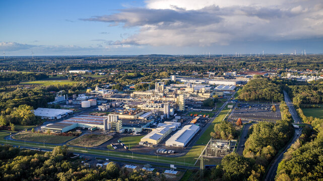 Aerial view of large industrial complex, chemical production plant, and manufacturing factory facilities surrounded by green fields and rural landscape in Hamm Uentrop, Germany.