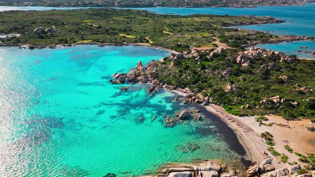 Drone view of Spiaggia Testa del Polpo beach area. Clear blue water, sandy shore and granite coastline create a beautiful Sardinian island landscape.