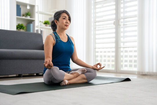Woman in sportswear doing meditate sitting on the floor. Healthy lifestyle concept.