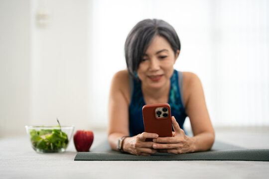 woman workout at home using mobile phone.