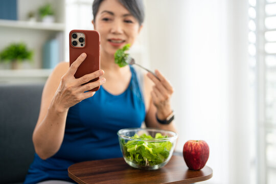 Woman with smartphone during exercise break in house.