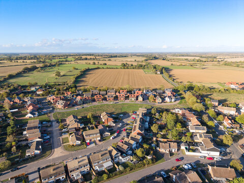 High-level drone view of part of the sprawling Essex, UK village of Blackmore. Showing both older houses and towards the back a newly completed housing development.
