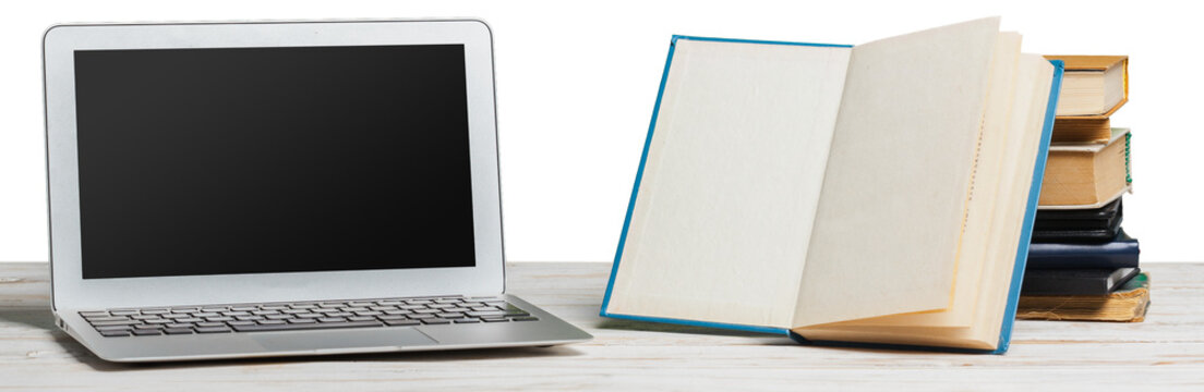 Workspace with a laptop and an open book beside a stack of books on a wooden table