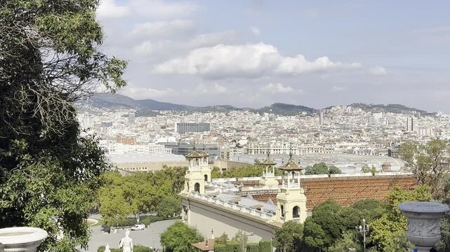 Barcelona, Spain, October 13, 2026 - View from the Palau Nacional on Montjuic hill overlooking statues along the grand staircase, crowds of visitors, and the cityscape of Barcelona.