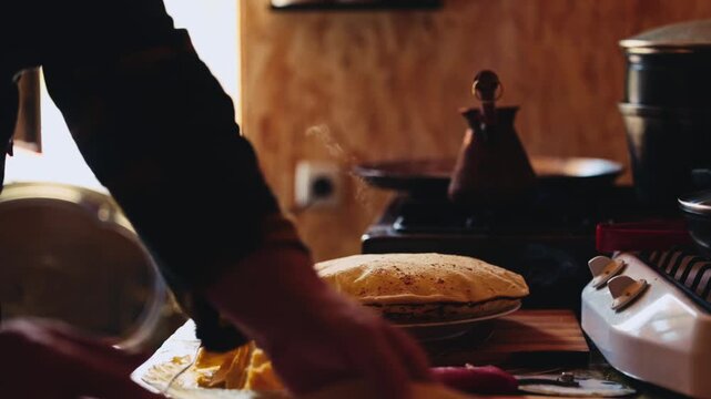 The process of making Traditional Balkar khychin, a thin stuffed flatbread from the North Caucasus, being prepared and cooked in a kitchen in slow motion video. Balkar cuisine and traditional food..
