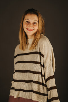 Young woman models a striped sweater in a studio portrait, offering casual fashion, knitwear, clothing and apparel content.