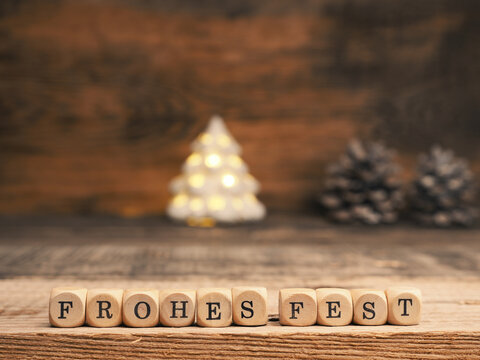 Small wooden block with the German words Frohes Fest and Christmas decoration