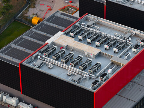 Aerial view of Aruba Hyper Cloud Datacenter IT4 featuring rows of industrial cooling units and HVAC systems on the flat rooftop of a modern building in Roma, Lazio, Italy.