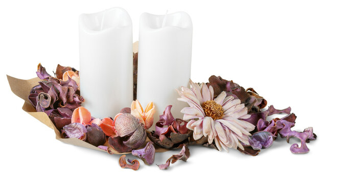 Decorative arrangement with white candles and dried flower petals on a simple background