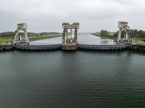 Aerial view of the Sluis- en stuwcomplex Hagestein, a historic weir and lock complex spanning the Lek River, with concrete structures and calm water in Hagestein, Utrecht, Netherlands.