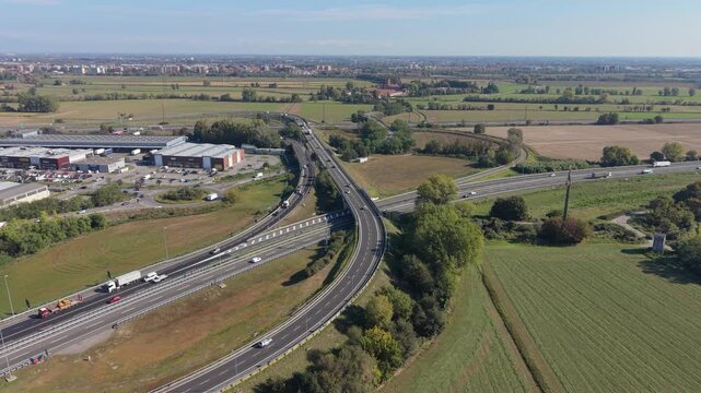 Aerial view of a major road interchange with cars moving through multiple connecting lanes in Milan, Italy.