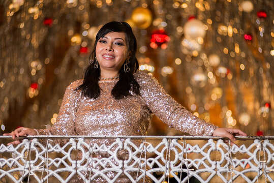 Woman in Elegant Dress Posing at a Festive Christmas Gazebo at Night