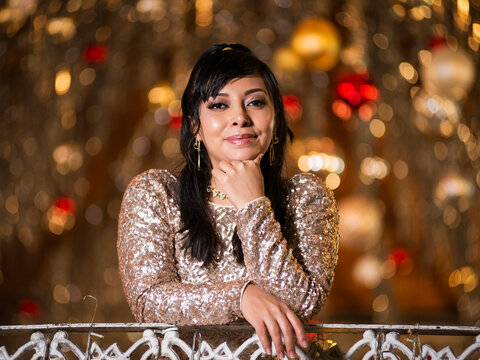 Woman in Elegant Dress Posing at a Festive Christmas Gazebo at Night
