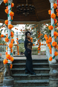 Catrina Woman in Traditional Dress on a Marigold Decorated Gazebo in Mexico