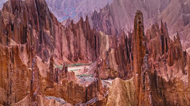 Aerial view of a dramatic red rock canyon with steep sandstone cliff formations in the Red Mountain Stone Forest, Kuqa, Xinjiang, China