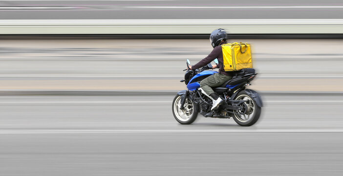 Abstract image of a courier on a motorcycle on a blurred background