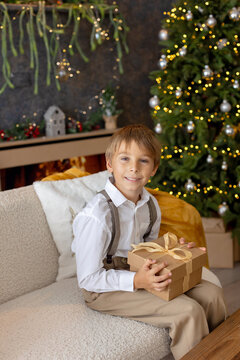 Happy child on Christmas, enjoying some quality time, opening presents, kids on Christmas eve in decorated home