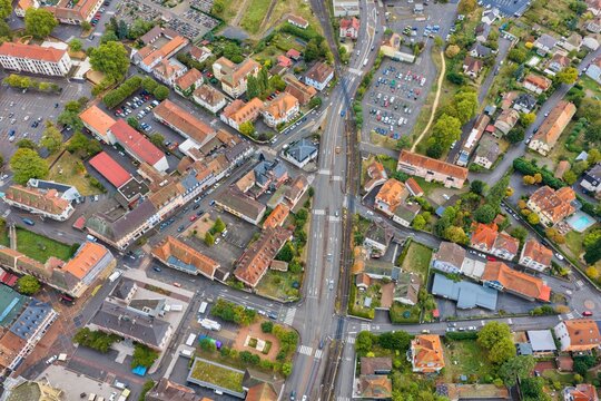 Aerial view of Thann, showing the historic town layout with its dense urban fabric, traditional rooftops, intersecting roads, and surrounding greenery in Thann, Grand Est, France.