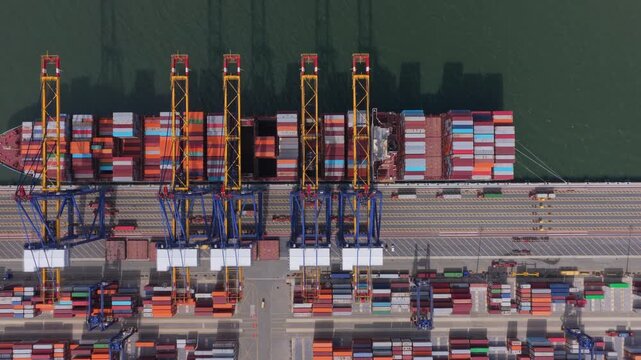 Aerial top down view of container ship loading and unloading at seaport terminal