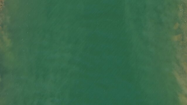Aerial view of Carter Lake Reservoir showing calm green water with subtle ripples and sandy shorelines in Larimer County, Colorado, United States.
