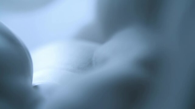 Soft blue abstract forms shift slowly through a defocused atmospheric field. Wellness promotion, technology branding, and title sequence.