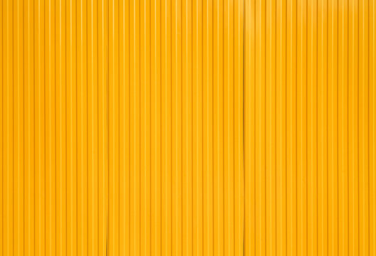 Yellow metal shipping container wall background with copy space.