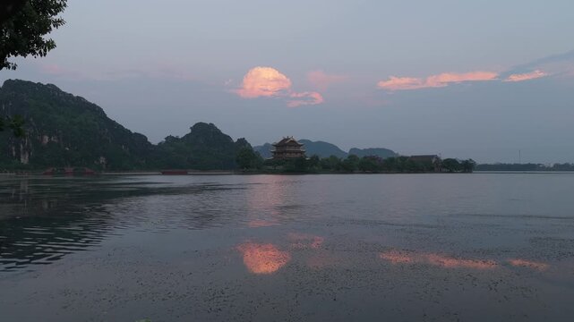 Golden pagoda reflecting in the water at sunrise in hoa lu vietnam