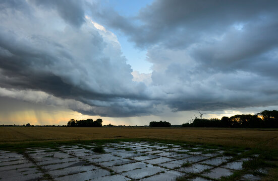 A heavy thunderstorm approaches empty fields in Benningbroek