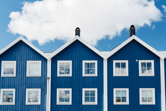 Blue wooden houses stand under a summer sky in Karlskrona Sweden