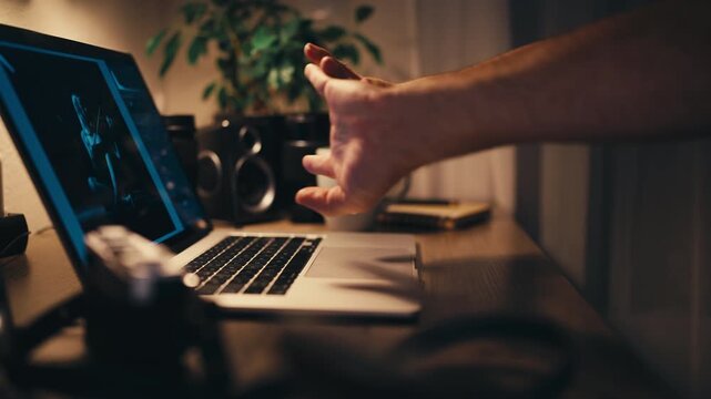 Man work on computer at night pauses with hot drink nearby while editing photographs. Concept of work breaks, maintaining focus, managing long hours, balancing professional tasks with moments of rest