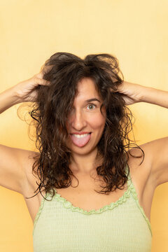 Playful woman sticking out tongue with messy hair