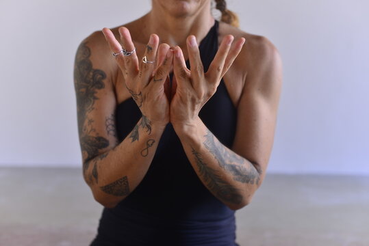woman doing yoga, woman practicing yoga holding padma lotus mudra hand gesture close up, athletic tattooed woman forming lotus hand mudra in studio, mindfulness meditation and wellness concept   