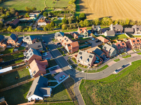 Near dusk aerial view of a newly completed private housing estate in Blackmore, Essex, UK. Showing both semi-detached, bungalows and detached family homes on a once Greenfield site.