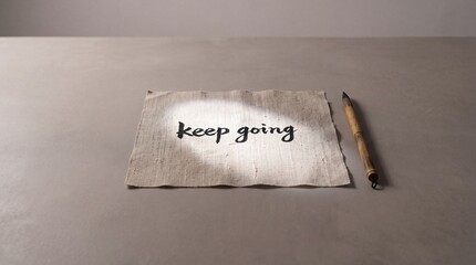 Naklejka premium Motivational Keep Going Text Written in Black Ink Calligraphy on Textured Fabric with Bamboo Brush on Grey Background Wide Context Minimalist Concept