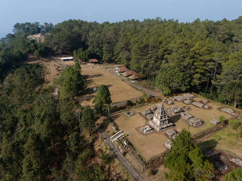 Aerial view of the historic Gedong Songo Temple complex surrounded by lush pine forests and the slopes of Mount Ungaran in Bandungan, Jawa Tengah, Indonesia.